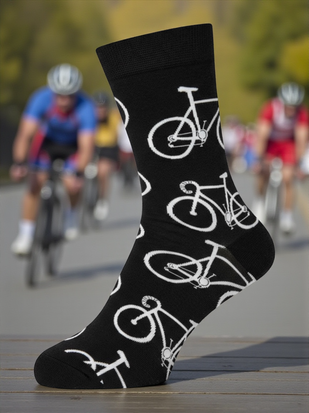 Black sock with white bicycle pattern worn by a person, with cyclists in the background.